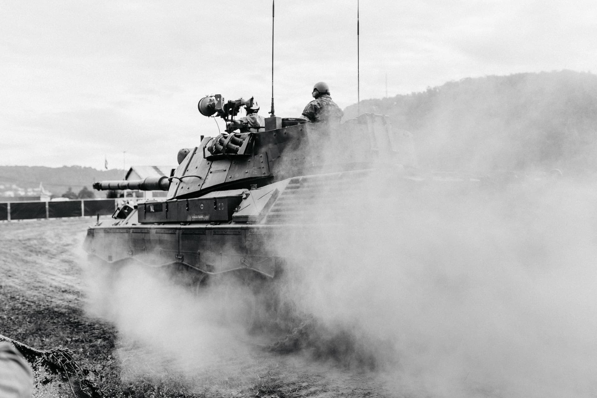 grayscale photo of soldiers on battle tank unsplash Kevin Schmid